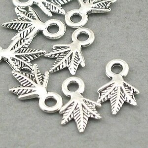 May include: Silver-toned metal leaf charms with a loop for jewelry making. The charms have detailed leaf vein patterns and are approximately 0.75 inches in length. Ideal for creating earrings, necklaces, or bracelets.