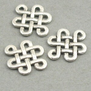 May include: Three silver metal Celtic knot charms. Each charm is a square shape with a knot design.