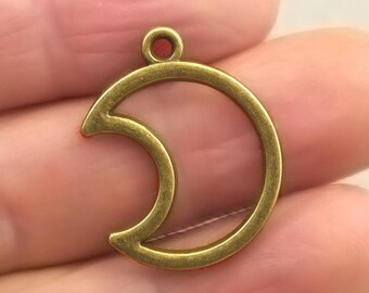 May include: Gold-toned metal crescent moon charm with a loop at the top for attaching to jewelry or other crafts.