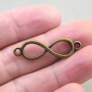 May include: A gold-toned infinity symbol charm with two jump rings for attaching to jewellery or crafts.