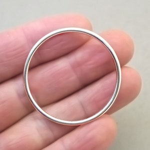 May include: A silver hoop earring with a smooth, polished finish.