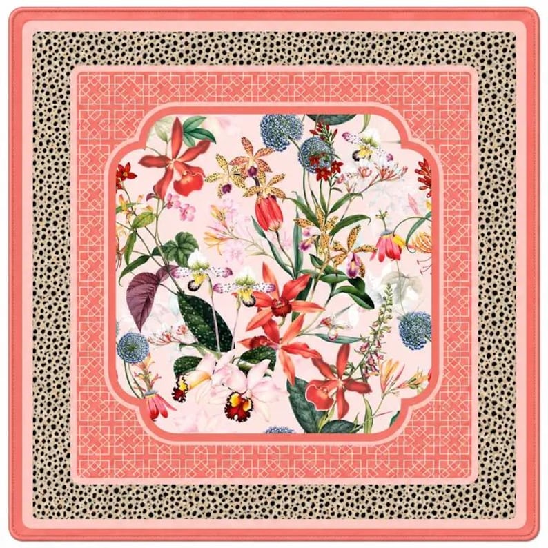 May include: A square scarf featuring a central panel of pink background with various colorful orchids and blue globe thistles. This is surrounded by a coral pink geometric lattice border and an outer frame of black and beige leopard print.