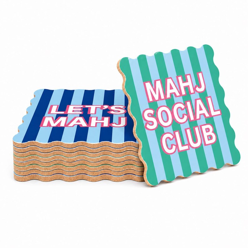 May include: A stack of square cork coasters with wavy edges. The top coaster features teal and light blue vertical stripes with the pink text MAHJ SOCIAL CLUB. The lower coasters have dark blue and light blue stripes with the pink text LET'S MAHJ.