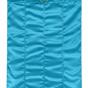 May include: A rectangular turquoise satin drawstring bag featuring vertical stitched channels. The top opening is secured with a matching turquoise cord threaded through gold-toned metal eyelets, finished with a small gold-toned cylindrical toggle.