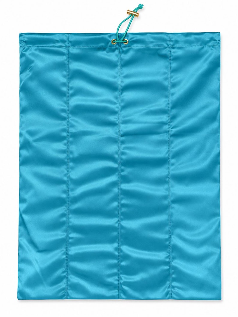 May include: A rectangular turquoise satin drawstring bag featuring vertical stitched channels. The top opening is secured with a matching turquoise cord threaded through gold-toned metal eyelets, finished with a small gold-toned cylindrical toggle.