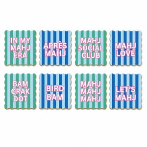May include: A set of eight square coasters with scalloped edges, featuring vertical blue and green stripes. Each coaster displays pink text: IN MY MAHJ ERA, APR&Egrave;S MAHJ, MAHJ SOCIAL CLUB, MAHJ LOVE, BAM CRAK DOT, BIRD BAM, MAHJ MAHJ MAHJ, and LET'S MAHJ.