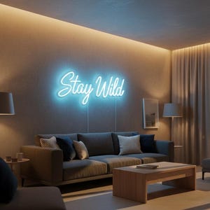 May include: A living room scene featuring a gray sofa with decorative pillows, a wooden coffee table, and a neon sign that reads "Stay Wild" in cursive script. The sign is illuminated with a bright blue light, adding a modern touch to the room's decor.