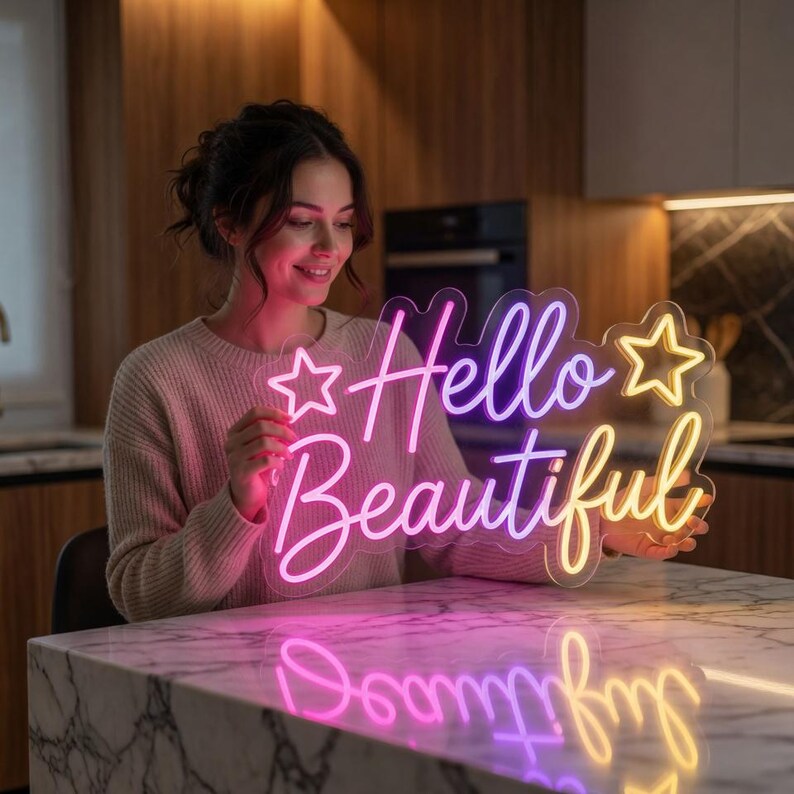 May include: A clear acrylic neon sign featuring the text Hello Beautiful in a cursive font, flanked by two star outlines. The sign emits a gradient glow transitioning from pink to yellow, with the text and stars illuminated against a transparent backing.