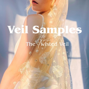 May include: A sheer, golden-toned veil with intricate floral embroidery. The text "Veil Samples" and "The Twisted Veil" are displayed in white. The veil is draped over a white dress, creating a soft, ethereal look.