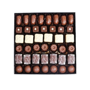May include: A box of assorted chocolates, featuring a variety of shapes and colors. The chocolates include dark and white chocolate pieces, with some having decorative patterns. The arrangement is neat, showcasing the different textures and designs of each piece.