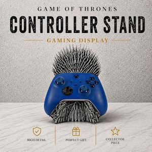 May include: A blue gaming controller rests on a stand designed to resemble the Iron Throne from Game of Thrones. The stand is made of silver-colored spikes. The words "CONTROLLER STAND" and "GAMING DISPLAY" are visible.