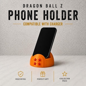 May include: Orange phone holder with four red stars, holding a black smartphone. The text "DRAGON BALL Z PHONE HOLDER COMPATIBLE WITH CHARGER" is at the top. The holder is a collector's piece.