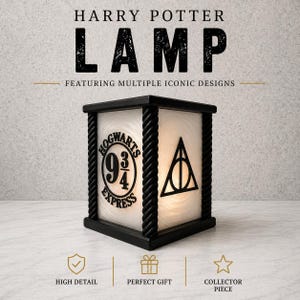 May include: Black rectangular Harry Potter lamp featuring iconic designs. The lamp has a black frame with a white interior. The front displays the Hogwarts Express logo and the Deathly Hallows symbol. The text "HARRY POTTER LAMP" is at the top.