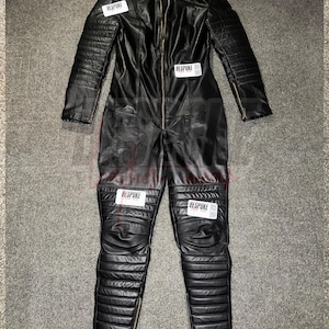 Mono de motorista de cuero auténtico: Mono de moto negro, paneles acanalados, ajuste personalizado.