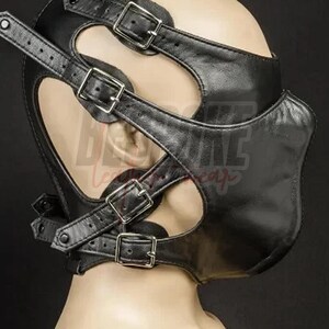 Puede incluir: Capucha de cuero negro con m&uacute;ltiples correas y hebillas met&aacute;licas. La capucha presenta cortes alrededor de los ojos y un dise&ntilde;o contorneado para el &aacute;rea de la boca. Las correas son ajustables.