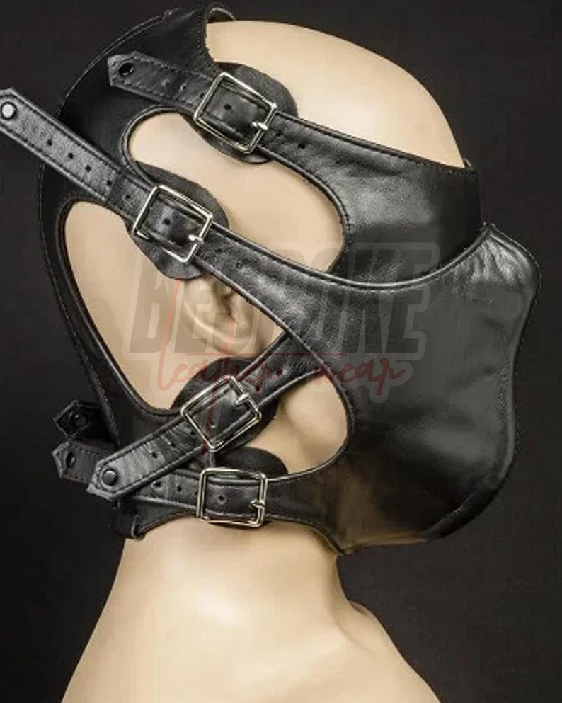 Puede incluir: Capucha de cuero negro con m&uacute;ltiples correas y hebillas met&aacute;licas. La capucha presenta cortes alrededor de los ojos y un dise&ntilde;o contorneado para el &aacute;rea de la boca. Las correas son ajustables.