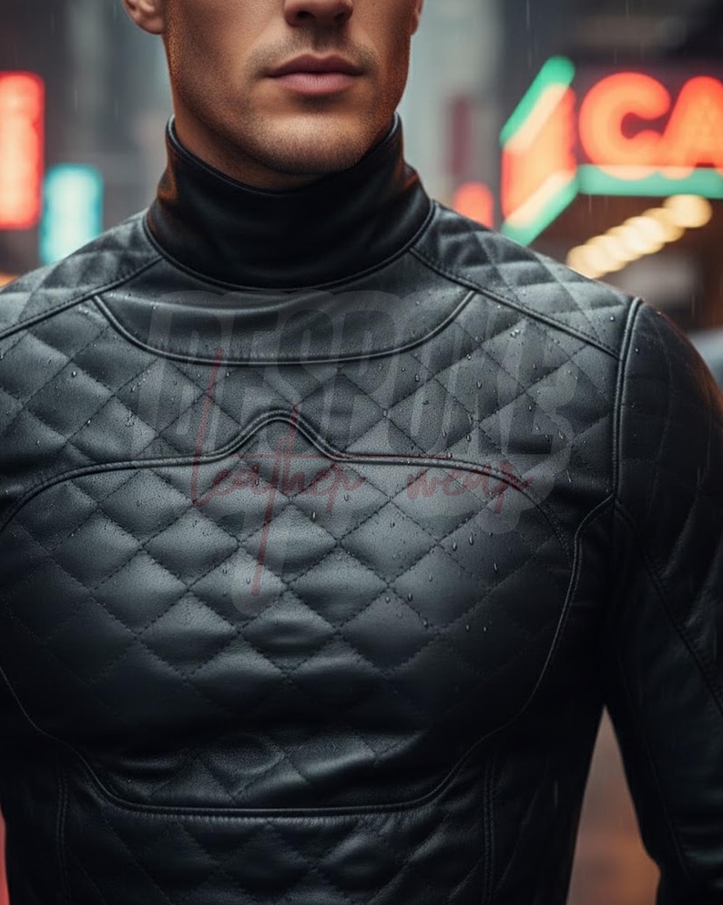 Op de afbeelding: Zwarte gewatteerde leren jas met een hoge kraag. De jas heeft een ruitpatroon en een strak, modern design. De afbeelding is een close-up, die de textuur en details van het kledingstuk benadrukt.