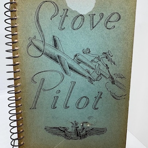 May include: Vintage cookbook titled "Stove Pilot" with a spiral binding. The cover features a teal and gray design with an illustration of a plane and a woman. The text "Favorite Recipes From Maxwell" is at the bottom.