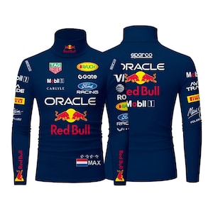 May include: Navy blue long-sleeved turtleneck shirt featuring multiple sponsor logos and the Red Bull logo. The shirt includes the text "ORACLE", "Red Bull", "TAG HEUER", and "MAX".
