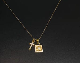 Gouden CH met een klein kruisje en een vierkant medaillon.