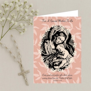 Puede incluir: Una tarjeta de felicitación con el texto "For A Special Mother To Be" y una ilustración de María y el niño Jesús. La tarjeta está sobre un fondo rosa con detalles de hojas blancas. Un rosario y flores están en la imagen.