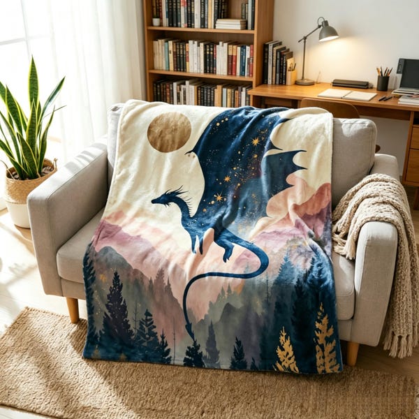 May include: A soft throw blanket featuring a dark blue dragon flying over a landscape of mountains and pine trees. The design includes a large golden moon and scattered stars against a cream-coloured background, with a watercolour-style aesthetic.