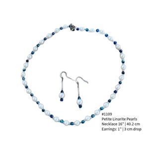 May include: A necklace and earring set featuring petite white pearls and dark blue beads. The necklace is 16 inches (40.2 cm) long, and the earrings have a 1-inch (3 cm) drop. The set is displayed on a white background.