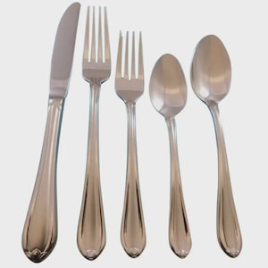 May include: A set of five stainless steel silverware pieces. The set includes a knife, two forks, and two spoons. The handles have a decorative, teardrop-shaped design. The silverware is arranged on a light background.