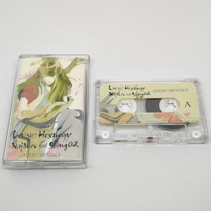 Puede incluir: Una cinta de cassette y su estuche transparente. El estuche presenta una ilustración de una persona con pelo largo verde y el texto "Lan(sic) Hexalogy Nujabes feat Shing02 INSTRUMENTALS". La cinta de cassette está etiquetada "Love Hexalogy Nujabes feat Shing 02 INSTRUMENTALS".