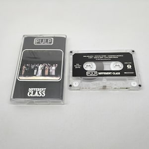 May include: A clear plastic cassette case and a matching cassette tape for the album Different Class by Pulp. The cover features a group photograph and the text Pulp and Different Class. The tape label lists tracks including Common People.