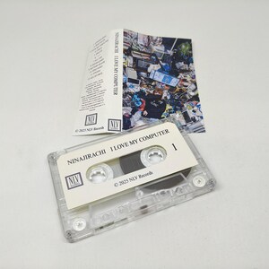 May include: A clear plastic cassette tape with a white label featuring the text NINAJIRACHI I LOVE MY COMPUTER and 2025 NLV Records. Included is a folded paper insert with a colourful, cluttered room graphic and a tracklist printed in black text.