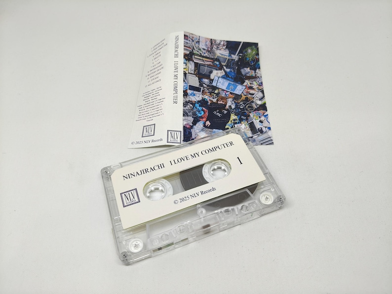May include: A clear plastic cassette tape with a white label featuring the text NINAJIRACHI I LOVE MY COMPUTER and 2025 NLV Records. Included is a folded paper insert with a colourful, cluttered room graphic and a tracklist printed in black text.