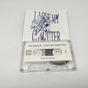 May include: A clear plastic cassette tape with a white label featuring the text NINAJIRACHI I LOVE MY COMPUTER, the NLV Records logo, and the year 2025. Behind the tape is a white paper insert with a blue line drawing and the text I LOVE MY COMPUTER.