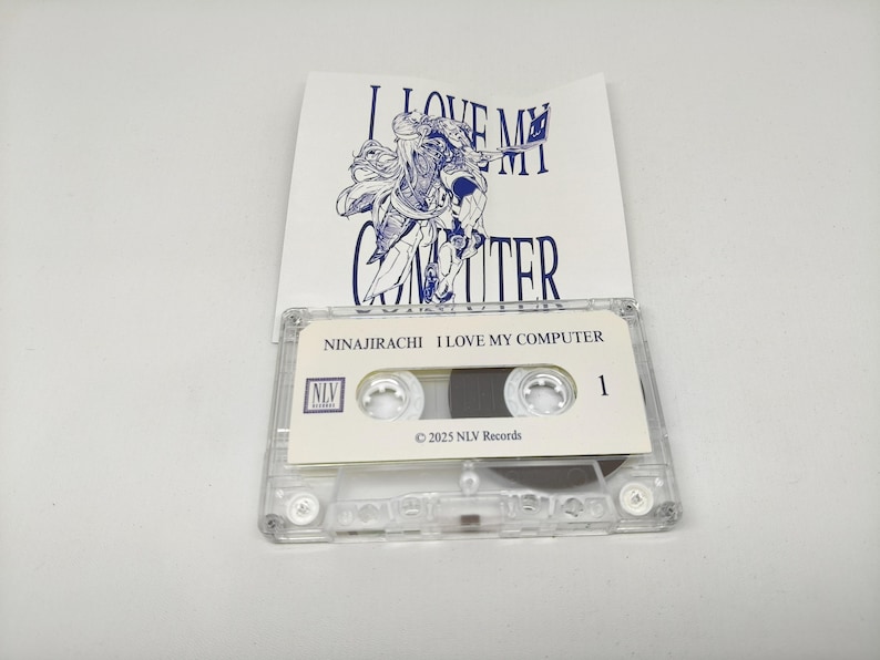 May include: A clear plastic cassette tape with a white label featuring the text NINAJIRACHI I LOVE MY COMPUTER, the NLV Records logo, and the year 2025. Behind the tape is a white paper insert with a blue line drawing and the text I LOVE MY COMPUTER.