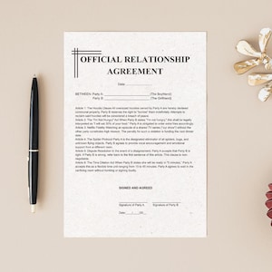 May include: A printed 'OFFICIAL RELATIONSHIP AGREEMENT' on cream paper, with text and signature lines. A black pen is on the left. The agreement covers hoodies, food, and TV shows, with humorous clauses for parties.
