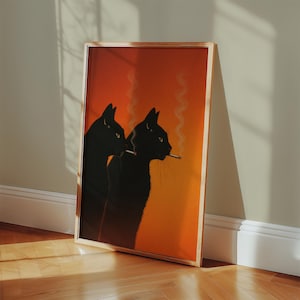 Peut inclure: Impression artistique encadrée représentant deux silhouettes de chats noirs sur un fond orange et jaune dégradé. Un chat tient une cigarette, avec de la fumée qui s'élève. L'œuvre est dans un cadre doré, appuyée contre un mur.