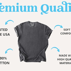 Pu&ograve; includere: Una maglietta grigio antracite con maniche arrotolate. Il testo nell'immagine recita "Premium Quality", "Stampato negli Stati Uniti", "Morbido e confortevole", "100% cotone" e "Realizzato con materiali di alta qualit&agrave;".