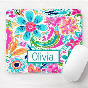 May include: A white mouse pad with a colorful floral pattern and the name "Olivia" printed in teal.