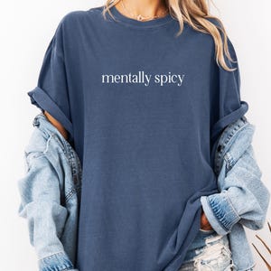 May include: An oversized navy blue t-shirt with the text "mentally spicy" printed in white on the front.