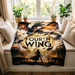 K&ouml;nnte beinhalten: Eine Fourth Wing-Decke mit einem Drachen mit feurigen Fl&uuml;geln und dem Buchtitel. Die Decke hat ein Fantasy-Thema mit einer Frau, die einen Speer h&auml;lt, vor dem Hintergrund einer Burg und eines feurigen Himmels.