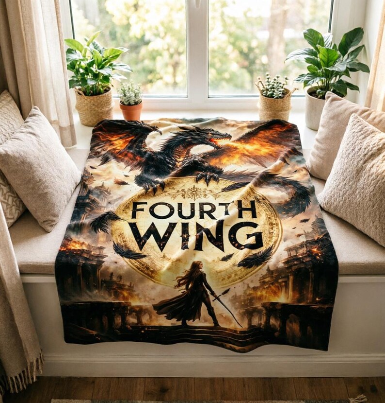 K&ouml;nnte beinhalten: Eine Fourth Wing-Decke mit einem Drachen mit feurigen Fl&uuml;geln und dem Buchtitel. Die Decke hat ein Fantasy-Thema mit einer Frau, die einen Speer h&auml;lt, vor dem Hintergrund einer Burg und eines feurigen Himmels.
