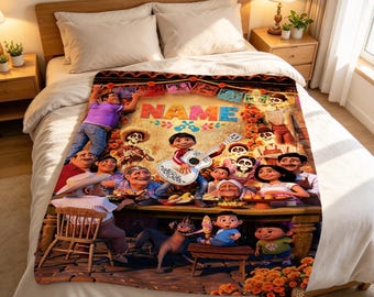 May include: A plush throw blanket featuring a colorful graphic print inspired by the movie Coco, displaying various characters, a central boy playing a guitar, and the text NAME at the top, draped over a bed with white bedding and pillows.