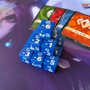 Puede incluir: Dados azules con números blancos apilados en forma de pirámide. Se ven varias cartas de juego, incluida una con el texto "Body Rune" sobre un fondo naranja. El fondo presenta un diseño morado y blanco.