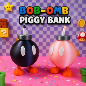 May include: Two Bob-Omb piggy banks, one black and one pink, with white oval eyes and orange feet. The text "BOB-OMB PIGGY BANK" is above them. The background includes a star, a coin, a mushroom, and other game-themed decorations.