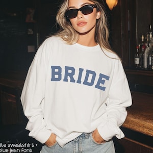 Bride Crewneck Bridal Sweatshirt Engaged gift for her custom mrs shirt announce engagement personalized wifey get married custom engaged shirt bride getting ready outfit future mrs engaged just engaged gift just married shirt bride hoodie mrs hoodie wifey sweatshirt bride mrs sweatshirt. bride clothes, wedding newly engaged gift. This is a custom bride crewneck bridal sweatshirt. It's a gildan 18000 crewneck sweatshirt.