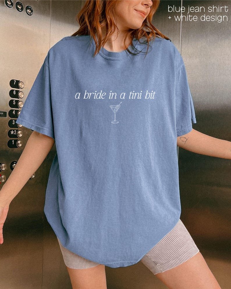 Bride in a Tini Bit Bride Shirt Tini Bit Engaged Bachelorette Party Custom Bachelorette Shirt for Bride to Be, Bride Sweatshirt Future Mrs Shirt, Mrs Personalized Bride Shirt | Bride Clothes Future Mrs Engaged Custom Mrs Shirt Custom Wife Shirt. Bridal Sweatshirt Bachelorette Shirts. Custom Bachelorette Shirt Bachelorette Party Shirts. Custom Bridesmaid Shirts This is a personalized getting ready outfit for wedding day. Perfect for a wedding newly engaged gift. It is a comfort colors 1717 shirt.