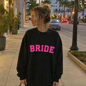 Bride Crewneck Bridal Sweatshirt Engaged gift for her custom mrs shirt announce engagement personalized wifey get married custom engaged shirt bride getting ready outfit future mrs engaged just engaged gift just married shirt bride hoodie mrs hoodie wifey sweatshirt bride mrs sweatshirt. bride clothes, wedding newly engaged gift. This is a custom bride crewneck bridal sweatshirt. It's a gildan 18000 crewneck sweatshirt.