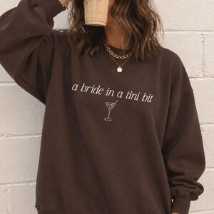 Bride in a Tini Bit Bride Shirt Tini Bit Engaged Bachelorette Party Custom Bachelorette Shirt for Bride to Be, Bride Sweatshirt Future Mrs Shirt, Mrs Personalized Bride Shirt | Bride Clothes Future Mrs Engaged Custom Mrs Shirt Custom Wife Shirt. Bridal Sweatshirt Bachelorette Shirts. Custom Bachelorette Shirt Bachelorette Party Shirts. Custom Bridesmaid Shirts This is a personalized getting ready outfit for wedding day. Perfect for a wedding newly engaged gift. It is a comfort colors 1717 shirt.