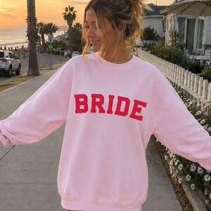 Bride Crewneck Bridal Sweatshirt Engaged gift for her custom mrs shirt announce engagement personalized wifey get married custom engaged shirt bride getting ready outfit future mrs engaged just engaged gift just married shirt bride hoodie mrs hoodie wifey sweatshirt bride mrs sweatshirt. bride clothes, wedding newly engaged gift. This is a custom bride crewneck bridal sweatshirt. It's a gildan 18000 crewneck sweatshirt.