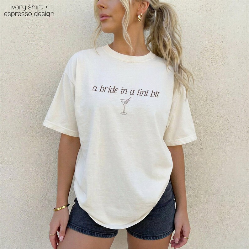 Bride in a Tini Bit Bride Shirt Tini Bit Engaged Bachelorette Party Custom Bachelorette Shirt for Bride to Be, Bride Sweatshirt Future Mrs Shirt, Mrs Personalized Bride Shirt | Bride Clothes Future Mrs Engaged Custom Mrs Shirt Custom Wife Shirt. Bridal Sweatshirt Bachelorette Shirts. Custom Bachelorette Shirt Bachelorette Party Shirts. Custom Bridesmaid Shirts This is a personalized getting ready outfit for wedding day. Perfect for a wedding newly engaged gift. It is a comfort colors 1717 shirt.